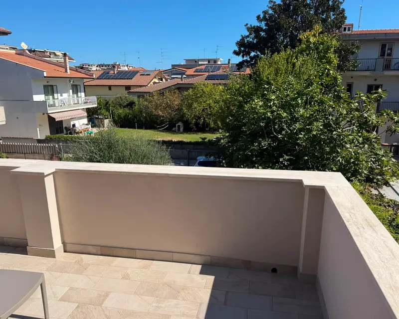 La terrazza pavimentata affacciata sui giardini e sui tetti